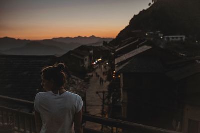 Rear view of man standing on mountain against sky