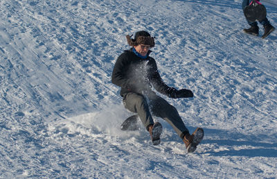 Low angle view of man sliding downhill on steep snow