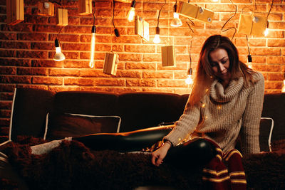 Young woman sitting on sofa