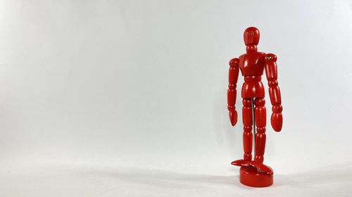 Close-up of red toy on table against white background