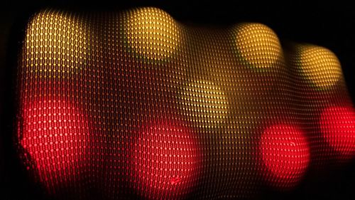 Close-up of illuminated light bulb against black background