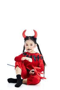 Portrait of cute girl against red background