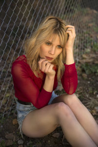 Portrait of young woman sitting on field