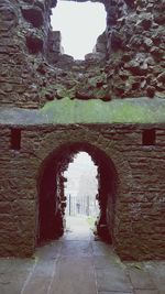 Archway leading towards arch against sky