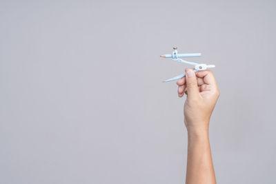 Midsection of person holding airplane against white background