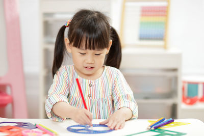 Girl drawing on paper at home