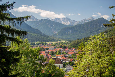 Scenic view of townscape by mountains against sky