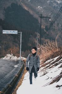 Full length of man on snow covered road