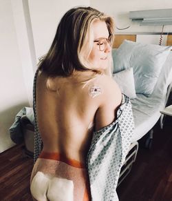 Rear view of naked woman after stem cell therapy at hospital