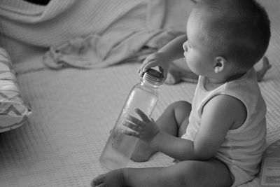 Midsection of baby boy sitting in bottle at home
