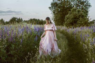 Woman standing on field with purple flowers