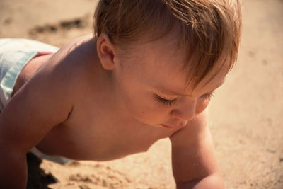 Midsection of shirtless boy on beach