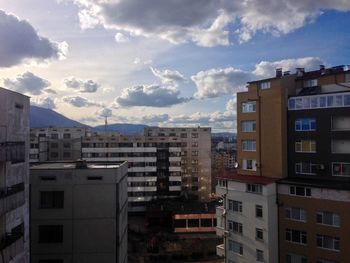 Buildings against cloudy sky