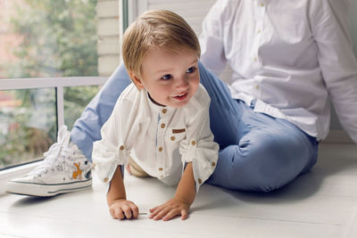 Father and son sitting by the window in the white room