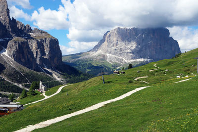 Scenic view of sella and sassolungo mountain groups against sky as seen from above gardena pass.