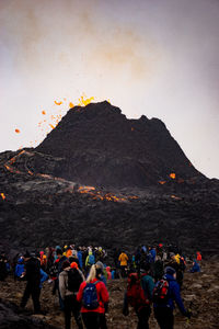 Group of people on mountain range against sky