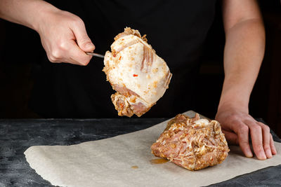 Midsection of man holding ice cream on table