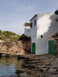 Houses by rocks and buildings against sky