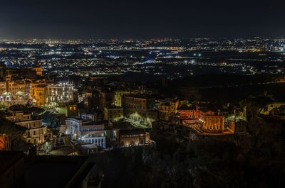 High angle view of illuminated buildings in city at night