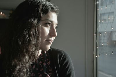 Close-up of thoughtful mid adult woman looking away at home