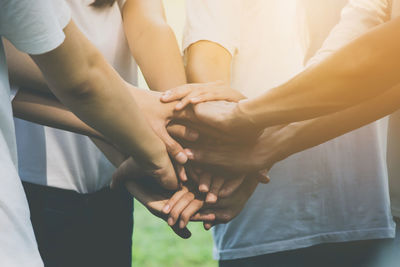 Midsection of women stacking hands together