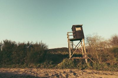 Water tower on landscape against clear sky