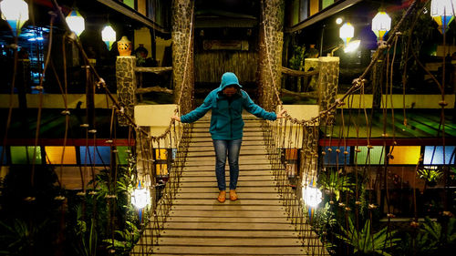 Rear view of woman walking on steps at night