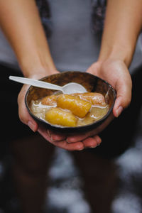 Midsection of woman holding food in bowl