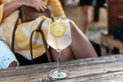 Close-up photo of refreshing lemonade in wine glass on table in beach bar