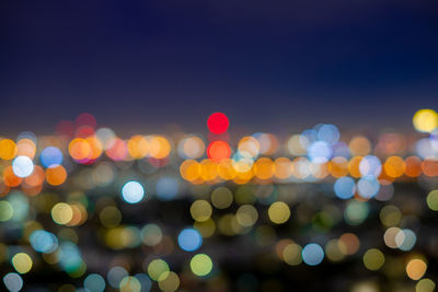 Defocused image of illuminated lights in city at night