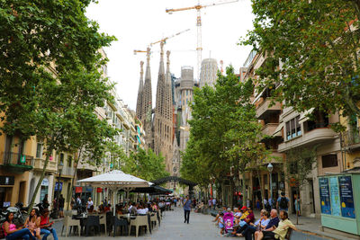 People on street amidst buildings in city