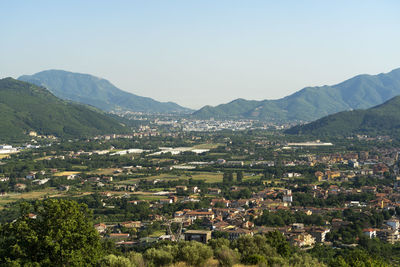 Aerial view of townscape and mountains against clear sky