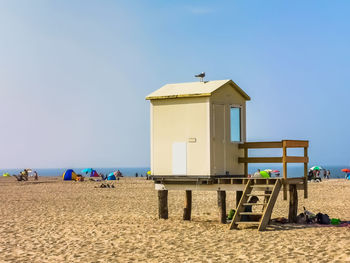 Built structure on beach against clear blue sky