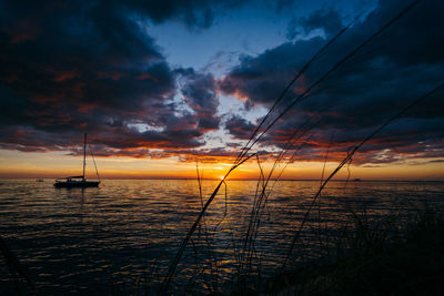 Scenic view of sea against dramatic sky during sunset