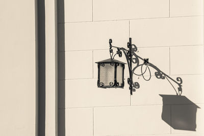 Low angle view of electric lamp hanging on wall