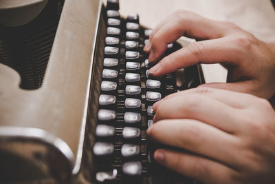 Cropped hands using typewriter on table 