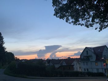 Houses and buildings against sky during sunset