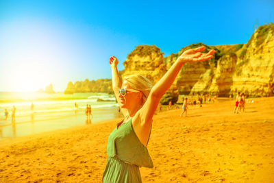 Woman standing at beach against sky