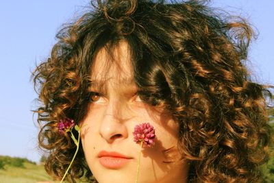 Close-up portrait of young woman against sky