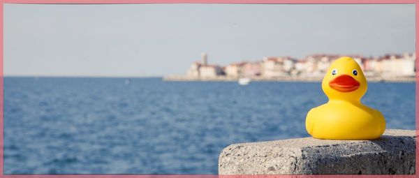 Close-up of yellow statue against sea