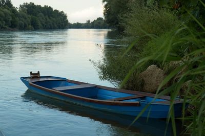 Boat moored in lake against sky