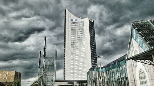 Low angle view of skyscrapers against cloudy sky