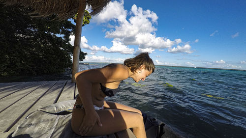 Side view of woman on beach against sky