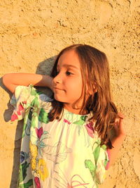 Close-up of thoughtful girl standing against wall