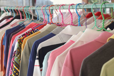 Multi colored clothes hanging on rack in store