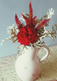 Close-up of red flower vase on table against wall