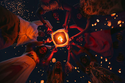 Directly below shot of women holding lantern at night