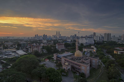 Aerial view of cityscape against cloudy sky