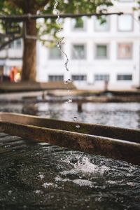 Water drops on fountain in city