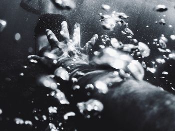 Close-up of man hand splashing water